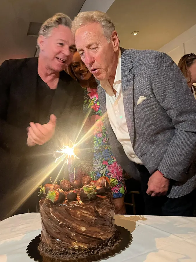 Friends lighting a sparkler on a chocolate cake