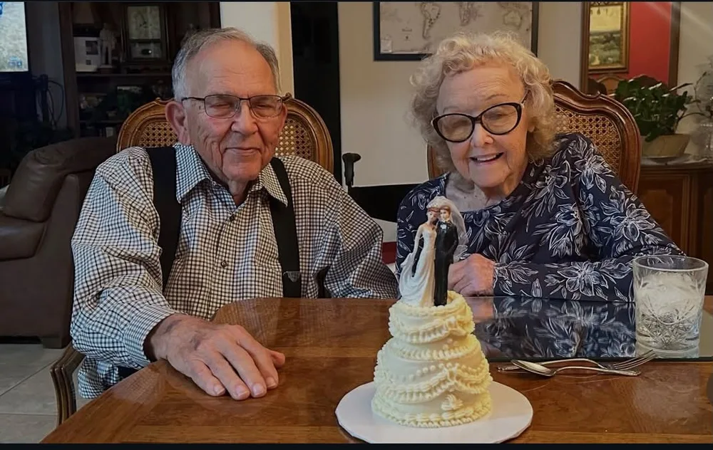 A couple sharing a little wedding cake at the table