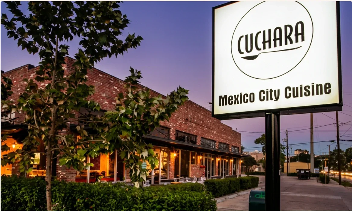 Cuchara’s brick building and its lit sign, Mexico City Cuisine, at dusk