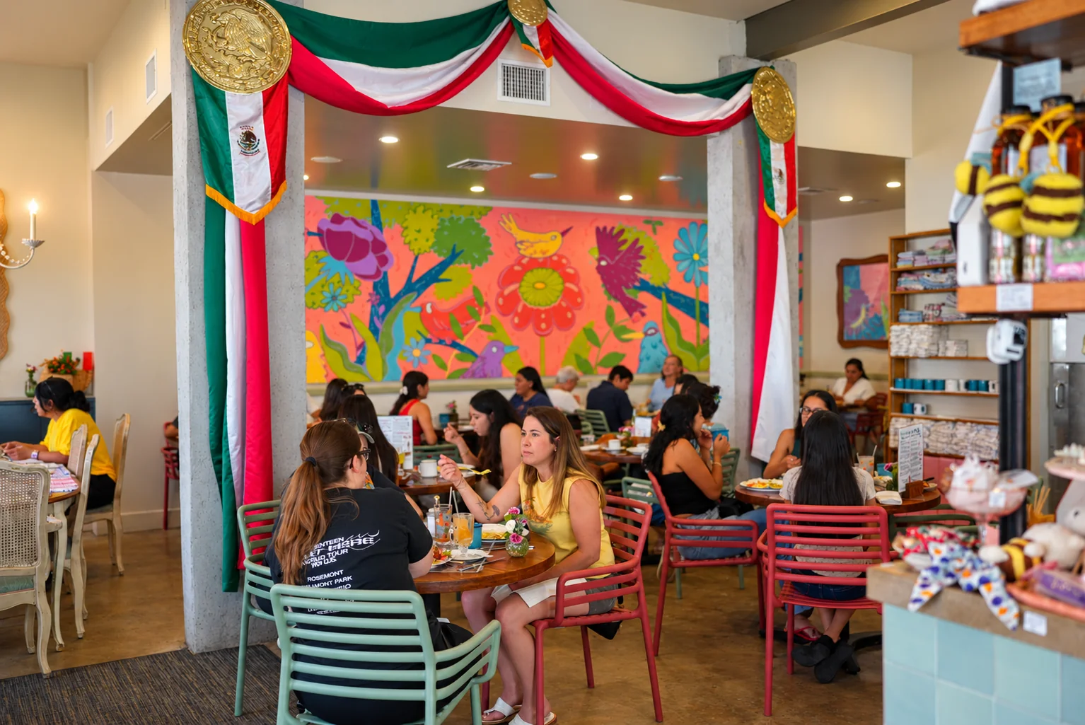 Friends gathered beneath the colorful mural at Cucharita