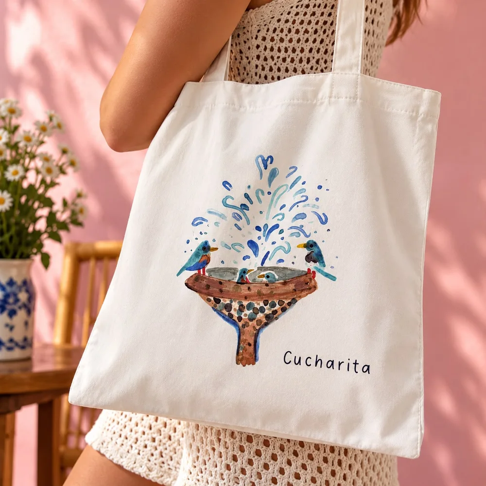 The Cucharita canvas tote with Cecilia Beaven’s fountain of birds, carried on the shoulder
