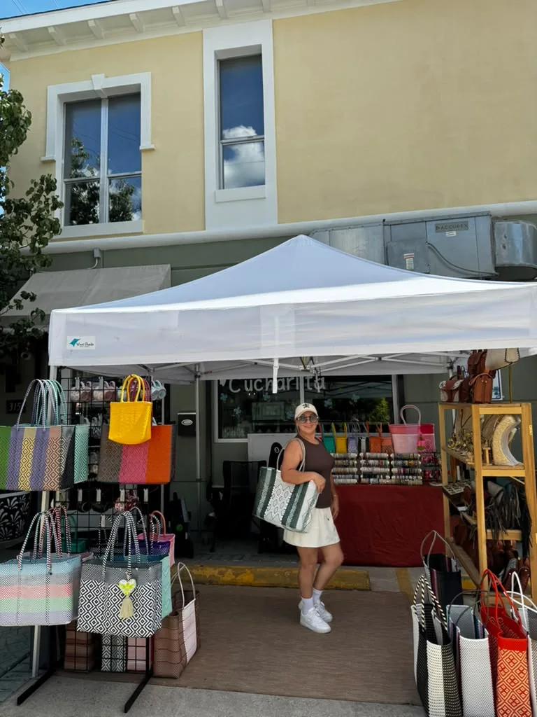 A local vendor with colorful woven bags outside Cucharita